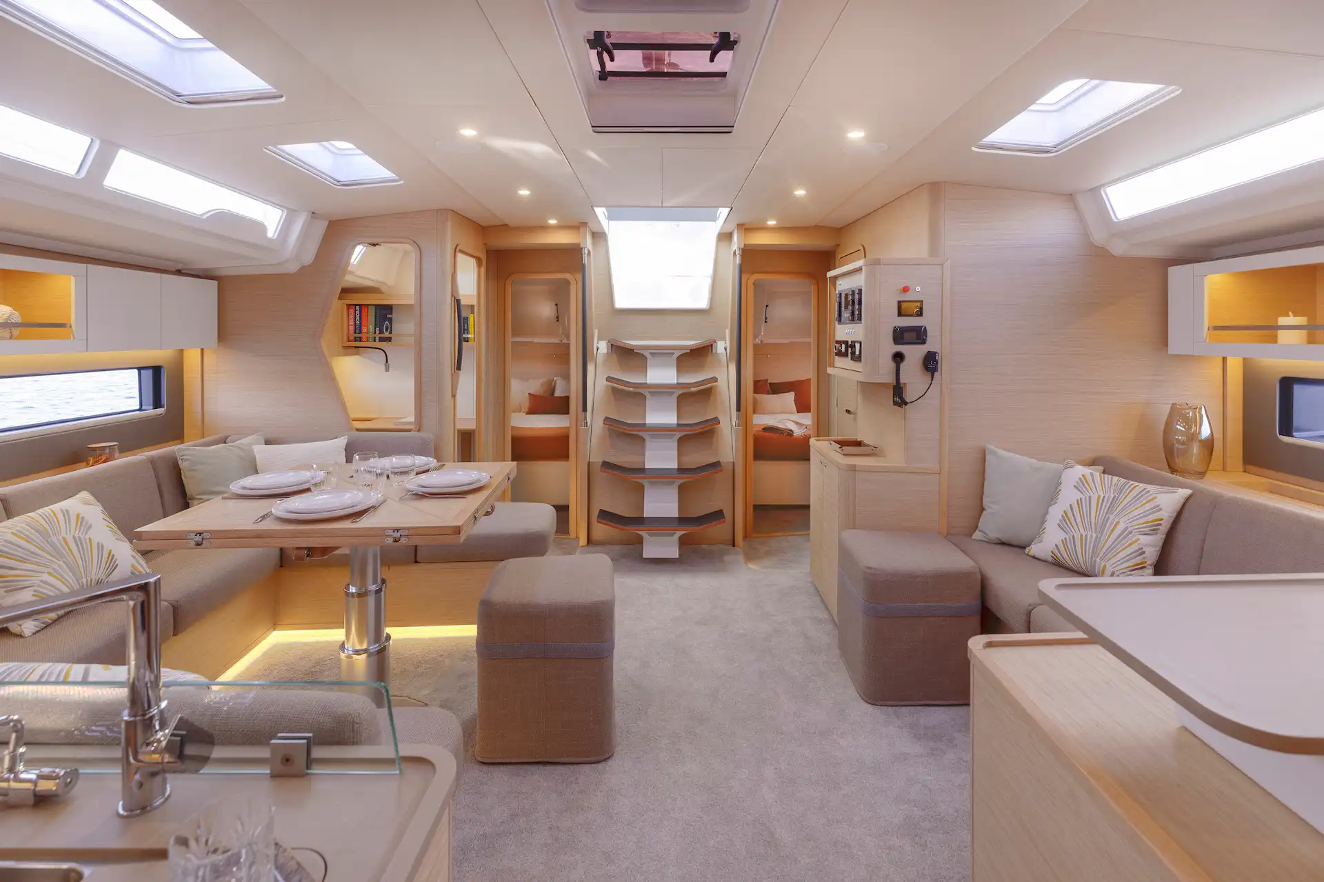 Hybrid Dufour 54 interior saloon with natural light, warm materials, and a calm, comfortable atmosphere designed for extended cruising