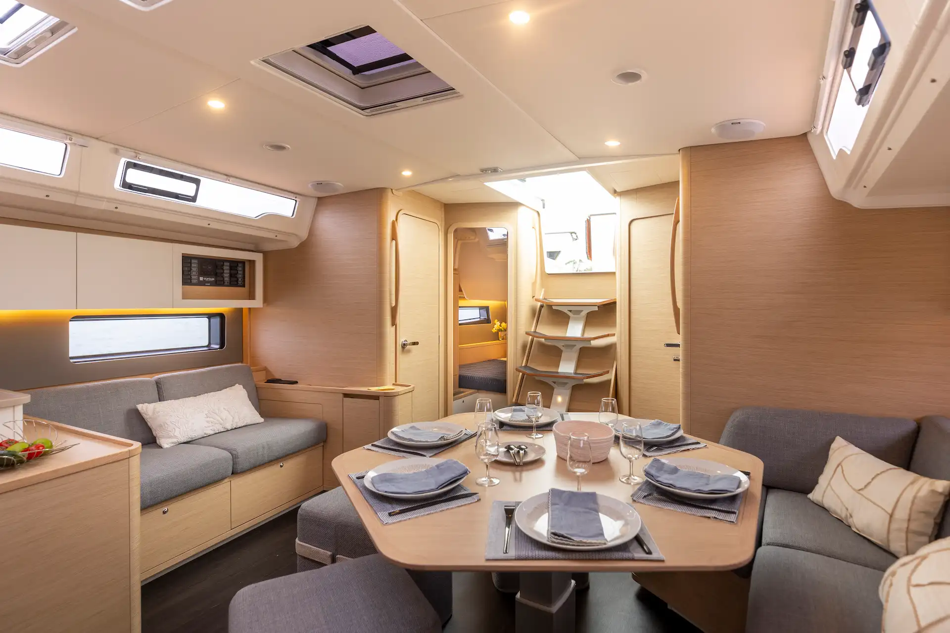 Interior saloon of the Dufour 44 Hybrid yacht featuring Joool electric system with modern dining area and natural light