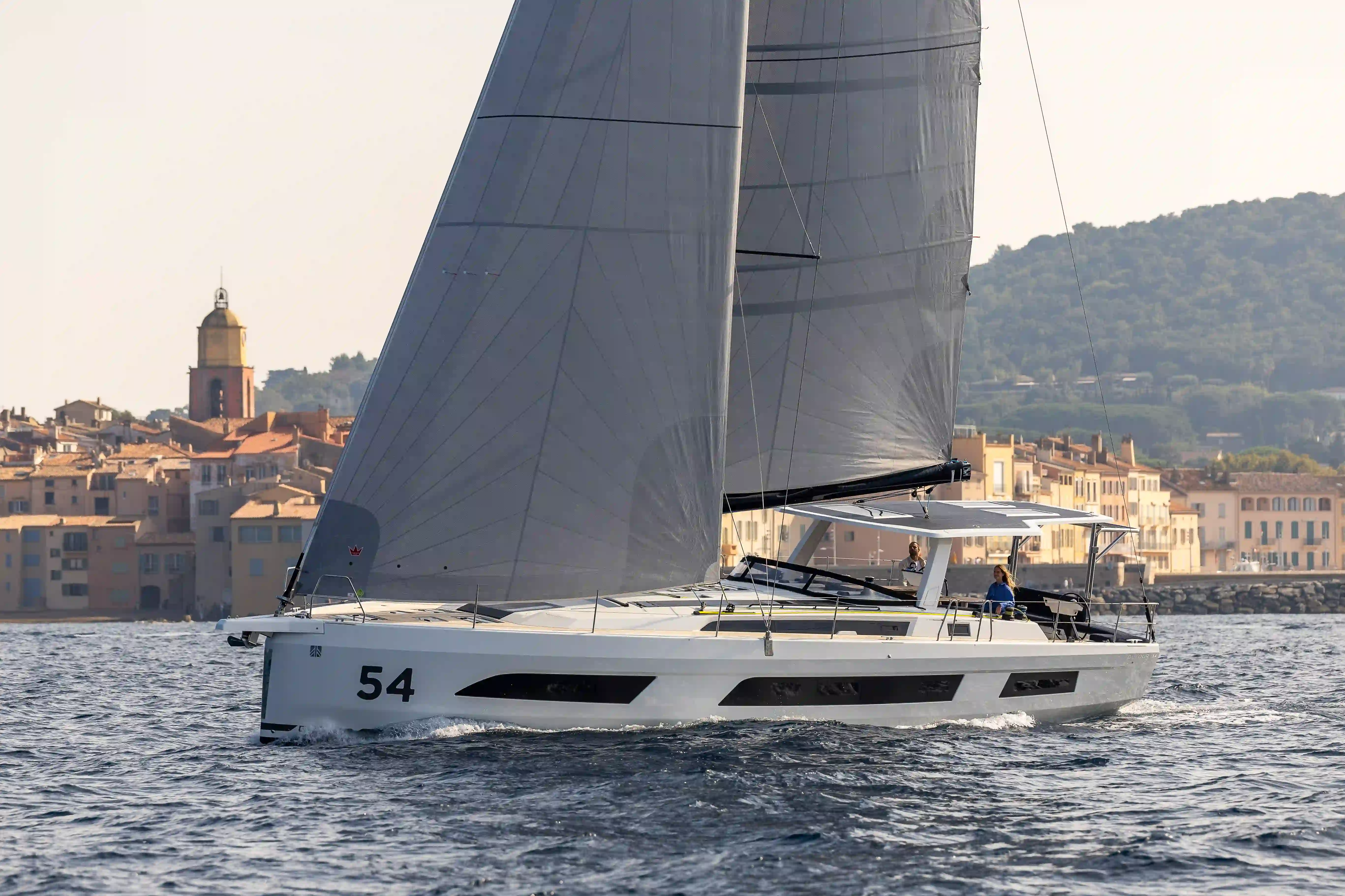 Hybrid Dufour 54 sailing along the coast under full sail, offering smooth navigation and a relaxed cruising experience in St Tropez