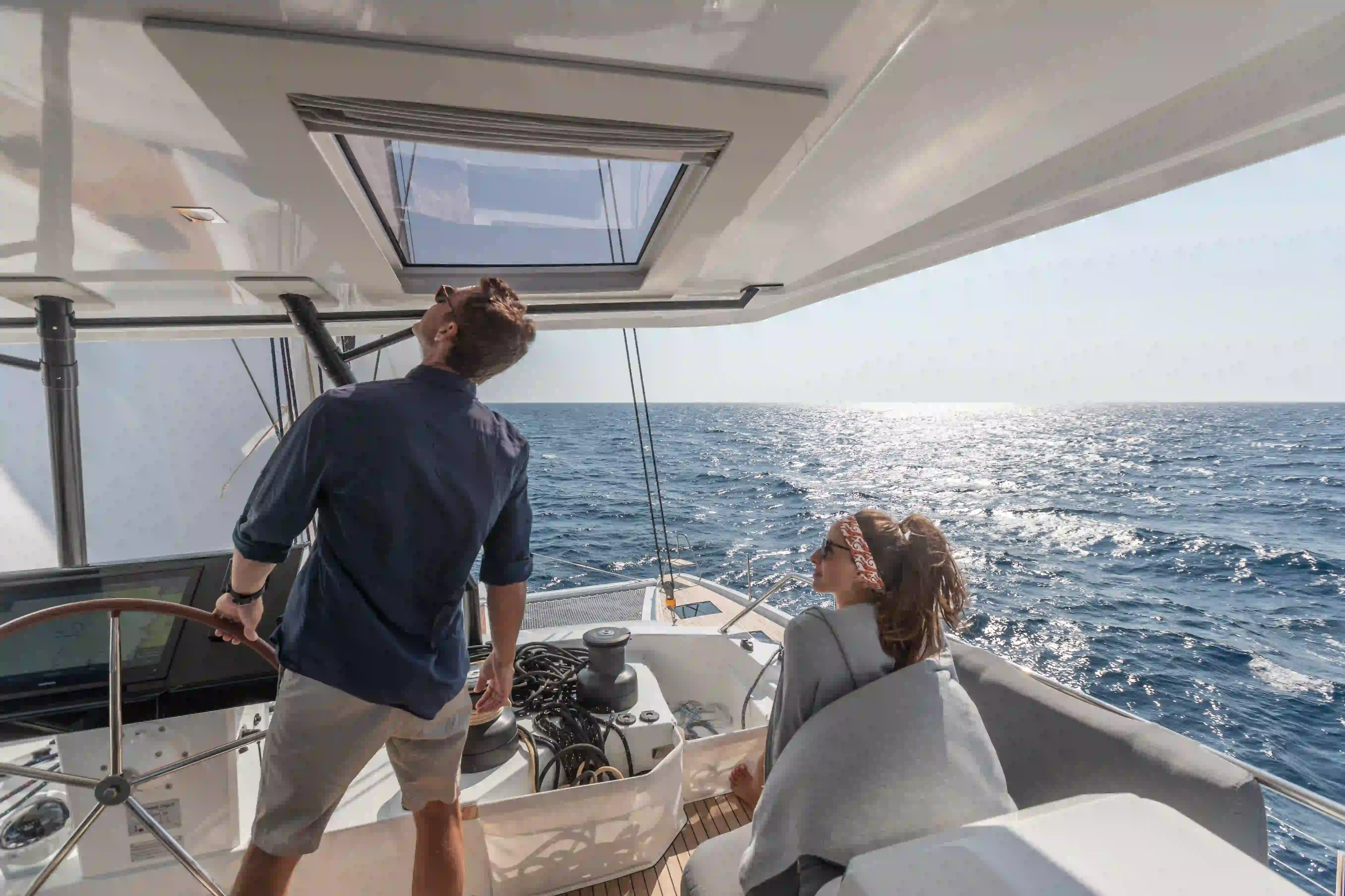 Hybrid Samana 59 electric catamaran flybridge while sailing with crew at the helm